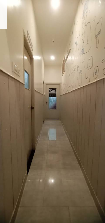 Clean clinic corridor with warm neutral wall paneling and operatory suites